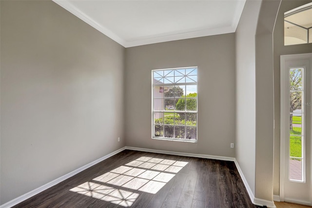 empty room featuring dark hardwood / wood-style floors, a wealth of natural light, and crown molding