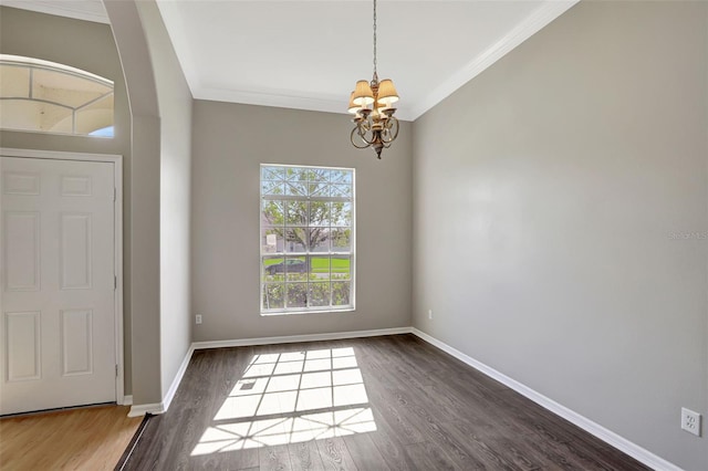 foyer featuring dark hardwood / wood-style floors, an inviting chandelier, and crown molding