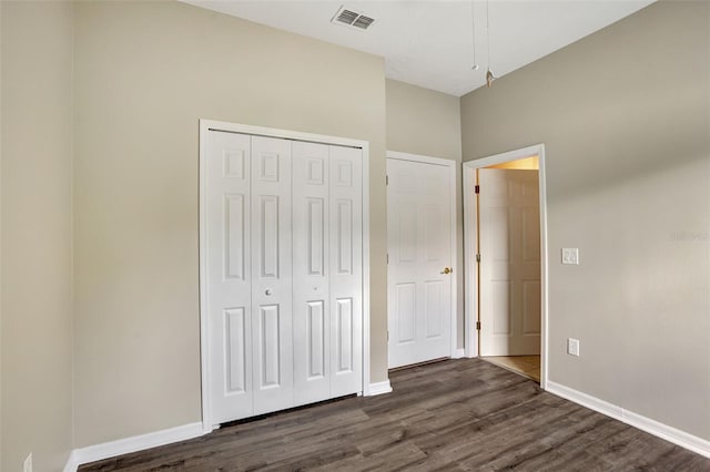 unfurnished bedroom featuring dark hardwood / wood-style floors and a closet