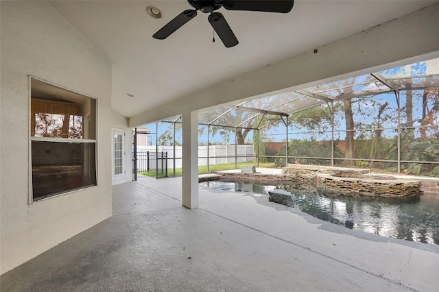 view of pool with a lanai, pool water feature, ceiling fan, and a patio