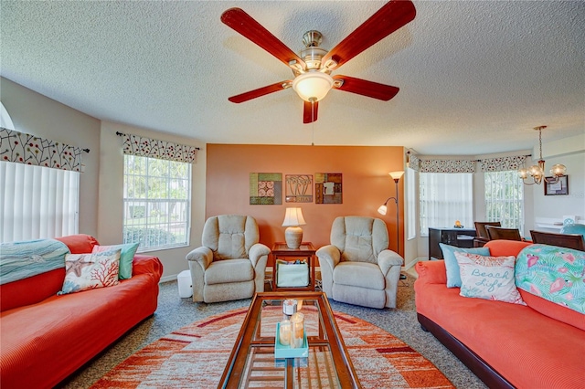 carpeted living room with ceiling fan with notable chandelier and a textured ceiling