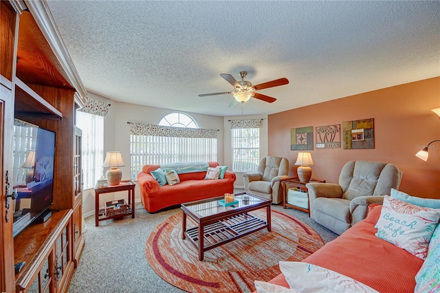 living room with ceiling fan, carpet floors, and a textured ceiling