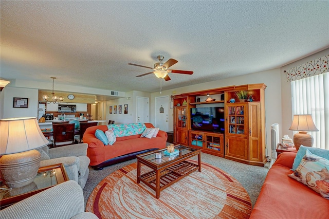 living room with a textured ceiling, ceiling fan with notable chandelier, and light carpet