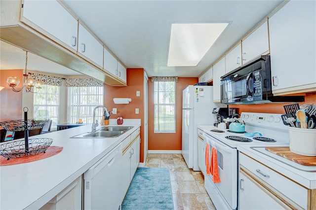 kitchen with pendant lighting, white appliances, white cabinets, sink, and a notable chandelier