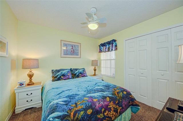 bedroom featuring ceiling fan, a closet, dark carpet, and a textured ceiling