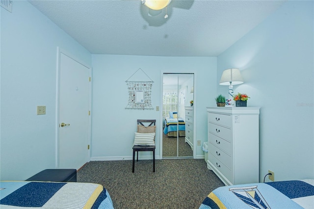 carpeted bedroom featuring ceiling fan, a closet, and a textured ceiling