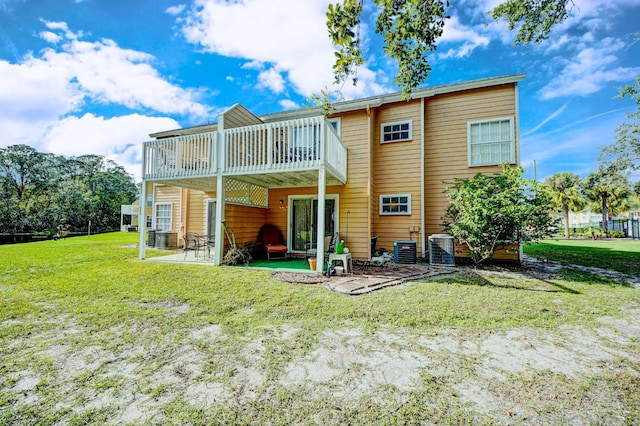 back of house featuring a lawn, a patio area, and a wooden deck