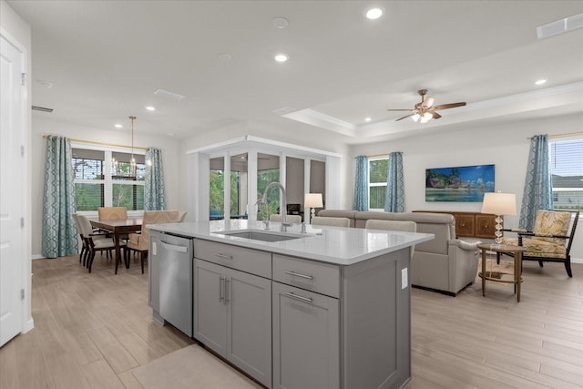 kitchen featuring stainless steel dishwasher, a healthy amount of sunlight, a center island with sink, and sink