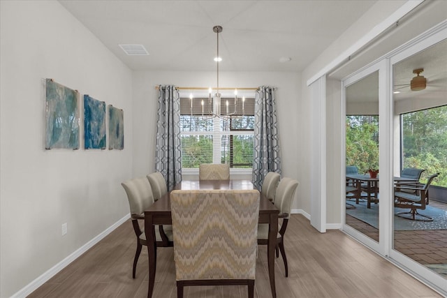 dining space with hardwood / wood-style floors and a chandelier