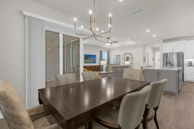 dining area featuring ceiling fan, sink, and light hardwood / wood-style floors