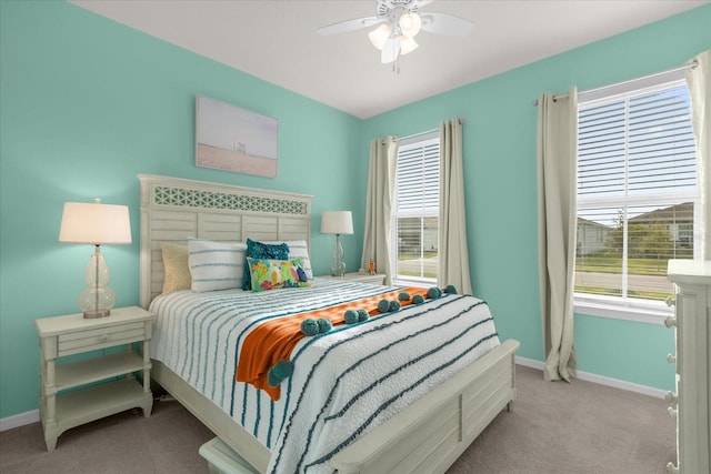 carpeted bedroom featuring multiple windows and ceiling fan