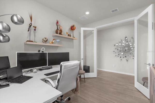 home office featuring french doors and light hardwood / wood-style floors