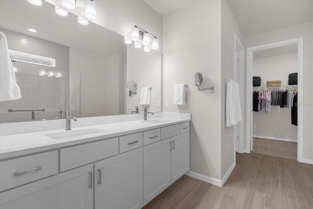 bathroom with hardwood / wood-style floors, vanity, and walk in shower