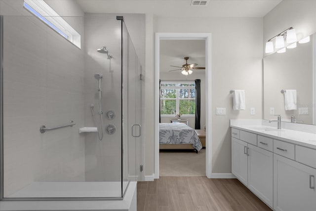 bathroom featuring hardwood / wood-style floors, vanity, walk in shower, and ceiling fan