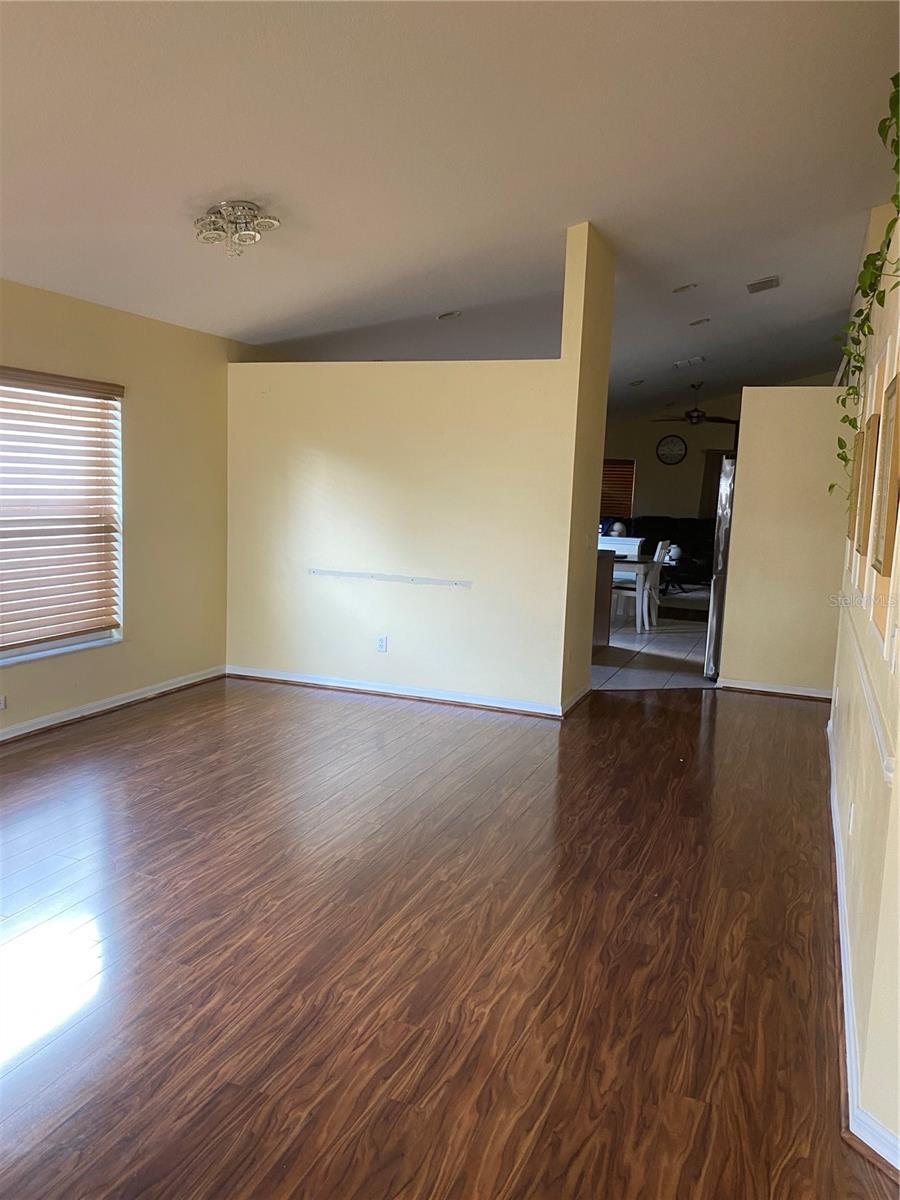 unfurnished living room with dark wood-type flooring and baseboards