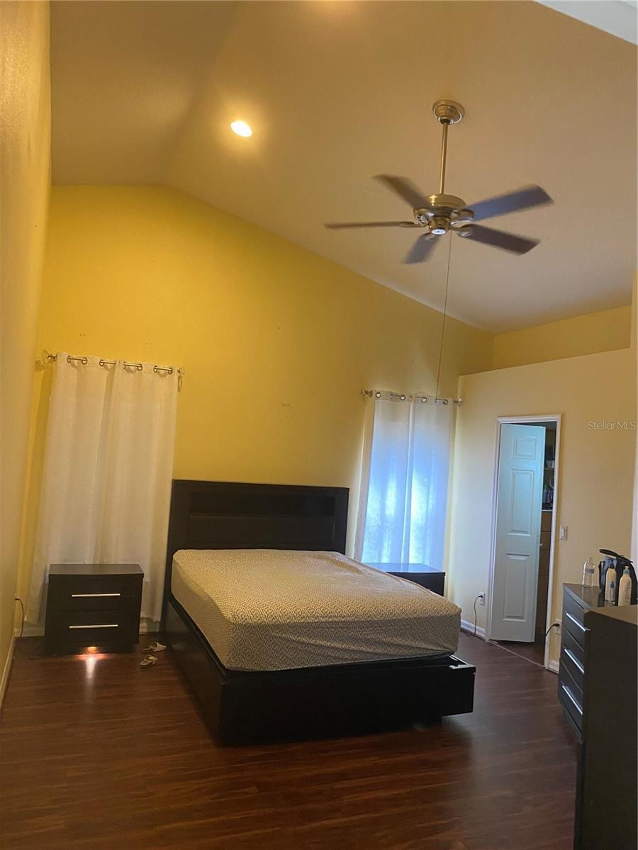bedroom with lofted ceiling, dark wood-style flooring, a ceiling fan, baseboards, and recessed lighting