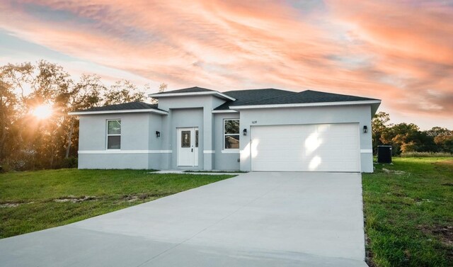 13869 SW 114th Pl, Dunnellon, FL 34432 - prairie-style house with concrete driveway, stucco siding, a garage, and a front yard