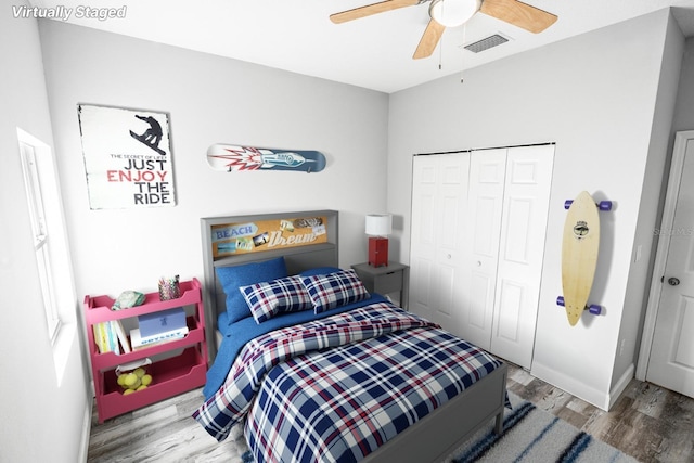 bedroom with hardwood / wood-style flooring, ceiling fan, and a closet