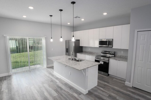 13869 SW 114th Pl, Dunnellon, FL 34432 - kitchen featuring appliances with stainless steel finishes, a sink, white cabinetry, a kitchen island with sink, and wood finished floors