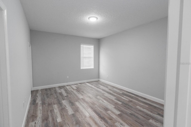 unfurnished room with light hardwood / wood-style floors and a textured ceiling