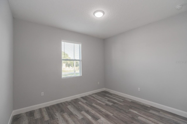 spare room with dark wood-type flooring and a textured ceiling