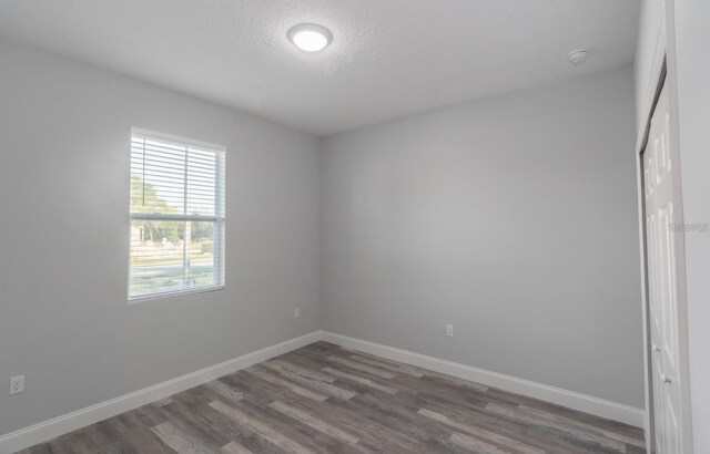 empty room featuring dark hardwood / wood-style flooring and a textured ceiling