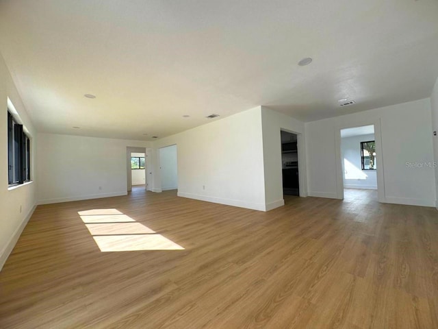 spare room with a wealth of natural light and light hardwood / wood-style floors