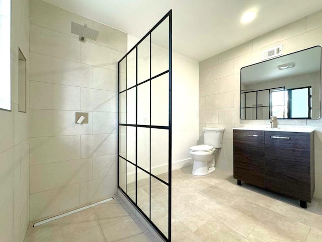 bathroom featuring tile walls, vanity, toilet, and a tile shower