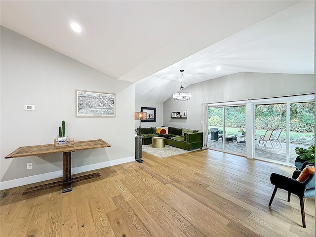 interior space featuring light hardwood / wood-style flooring, lofted ceiling, and a notable chandelier