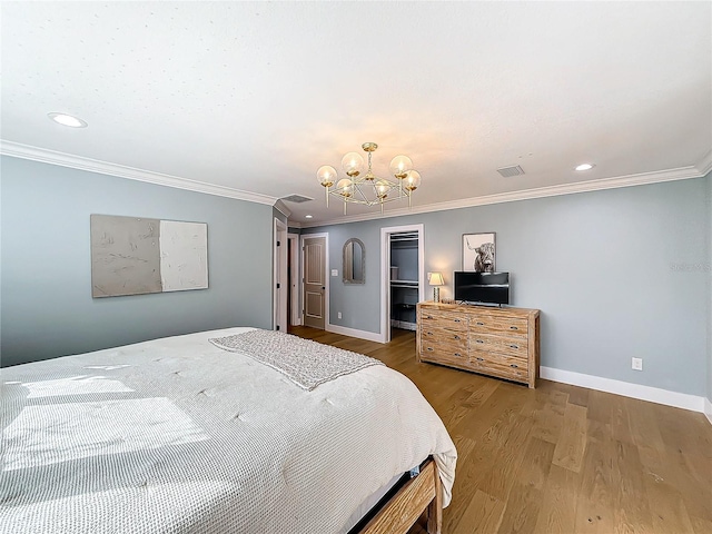 bedroom with hardwood / wood-style floors, an inviting chandelier, and ornamental molding