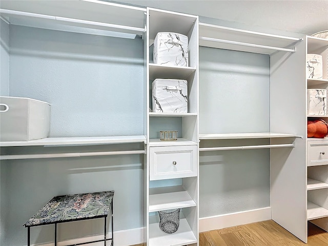 walk in closet with light wood-type flooring