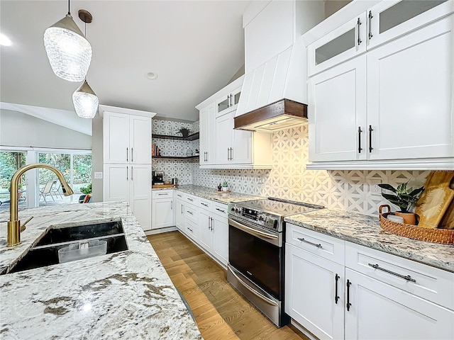 kitchen featuring sink, stainless steel range with electric cooktop, light hardwood / wood-style floors, decorative light fixtures, and white cabinets