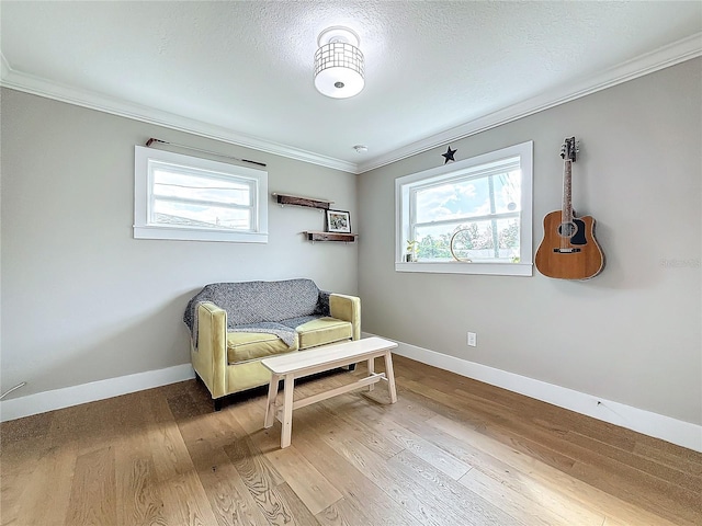 sitting room with crown molding, a textured ceiling, and hardwood / wood-style flooring