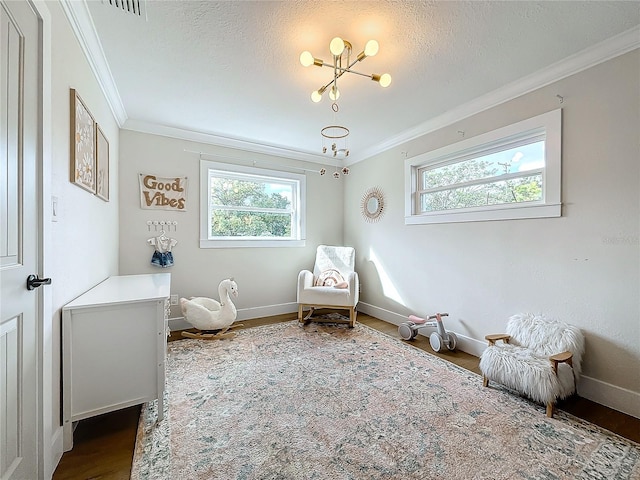 living area featuring a textured ceiling, wood-type flooring, crown molding, and a chandelier