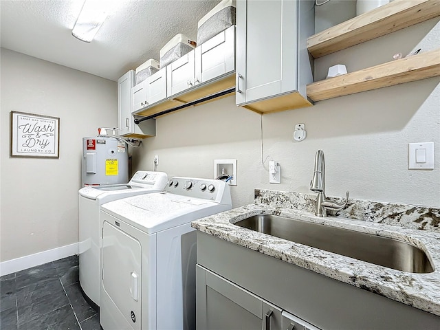 washroom with cabinets, electric water heater, sink, independent washer and dryer, and a textured ceiling