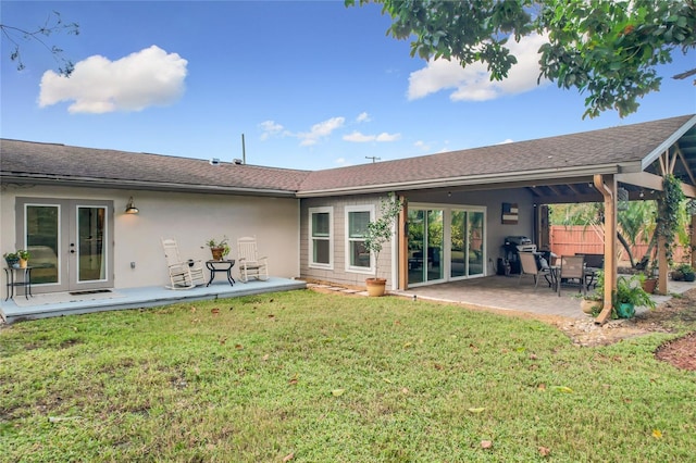 back of house with a lawn, a patio area, and french doors