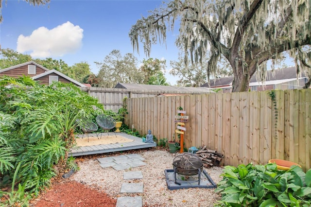 view of yard featuring a deck and an outdoor fire pit