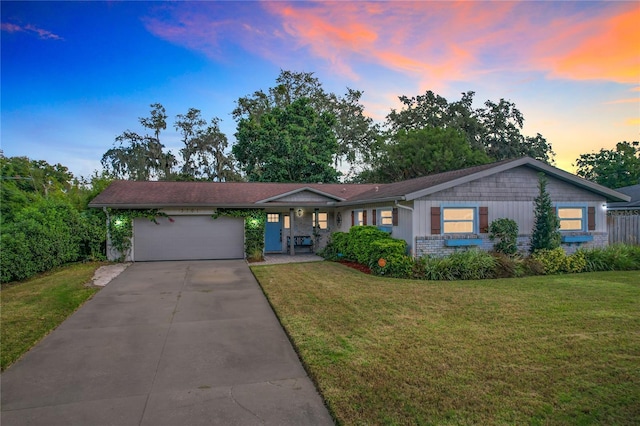 ranch-style house featuring a yard and a garage