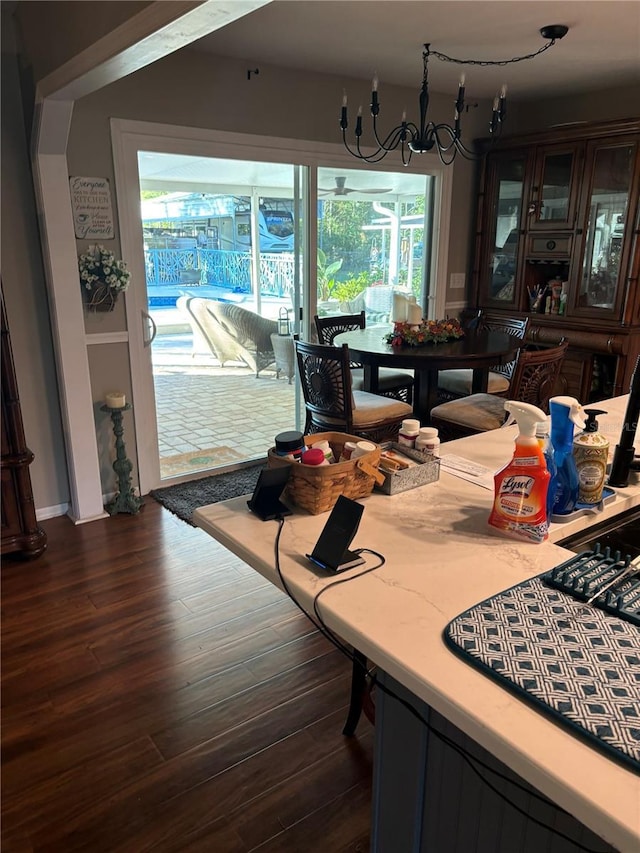 dining space with dark hardwood / wood-style floors, plenty of natural light, and a chandelier