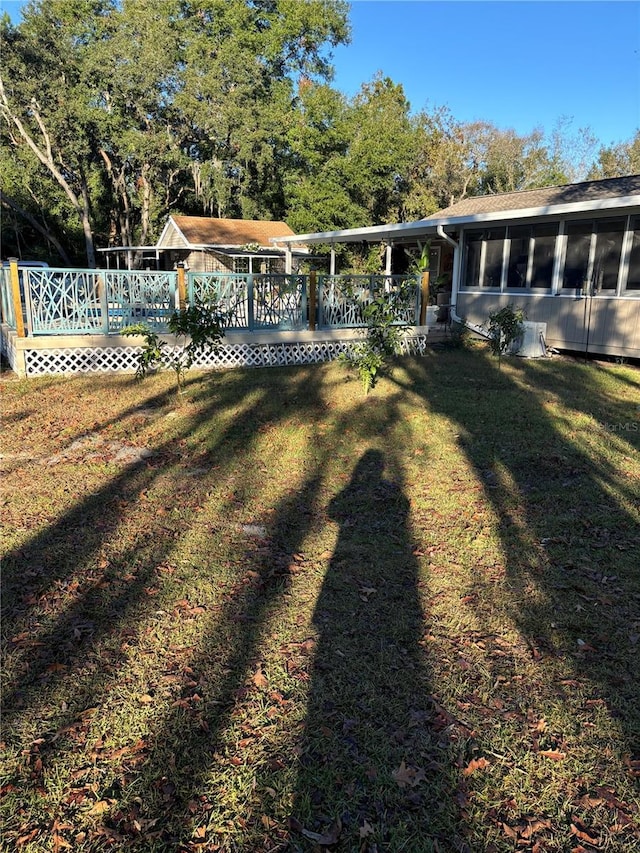 view of yard with a sunroom and a wooden deck