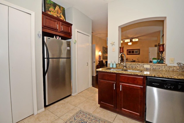 kitchen featuring sink, light tile patterned flooring, light stone counters, and appliances with stainless steel finishes