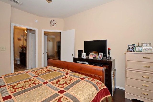 bedroom featuring connected bathroom and dark hardwood / wood-style floors