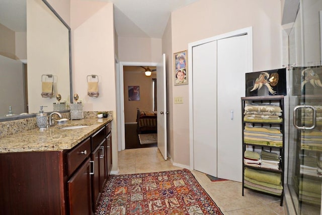 bathroom with tile patterned flooring, an enclosed shower, and vanity