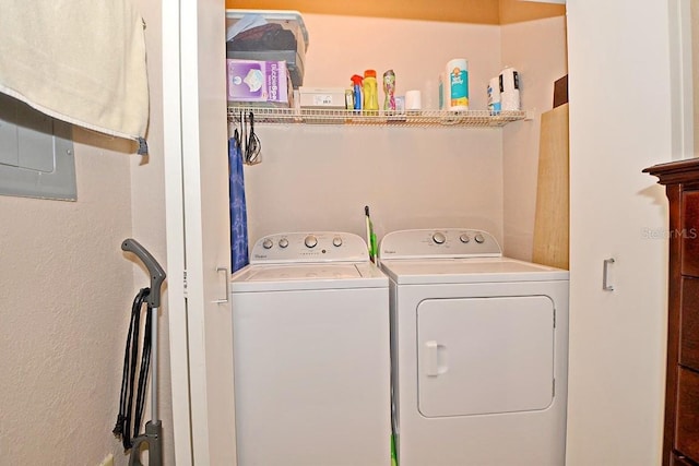 clothes washing area with separate washer and dryer and electric panel