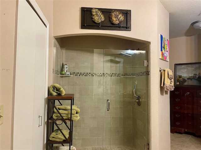 bathroom with tile patterned floors and a shower with door