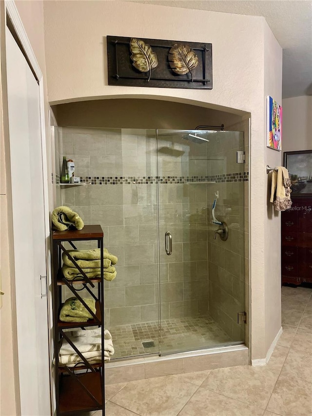 bathroom featuring walk in shower and tile patterned flooring