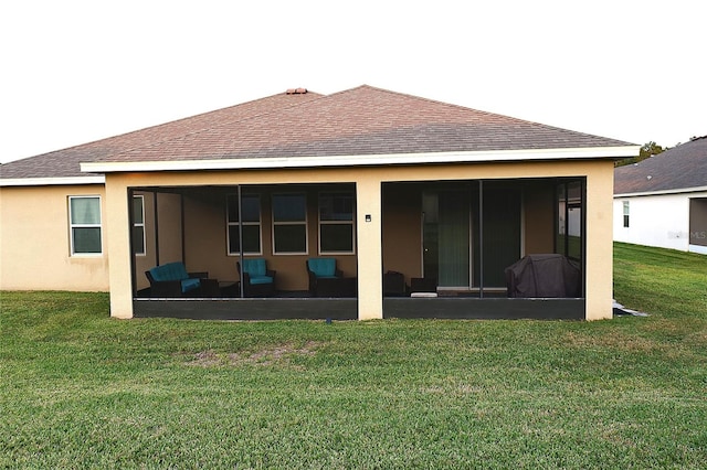 rear view of house with a lawn and a sunroom