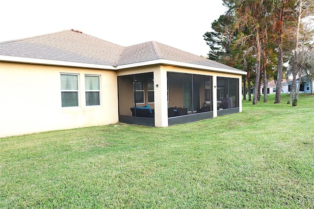 back of property with a lawn and a sunroom