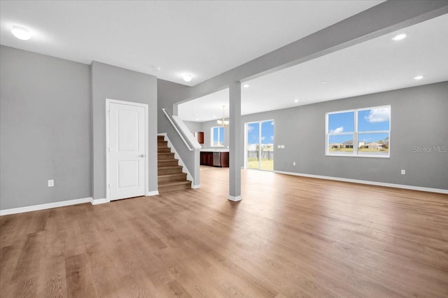 interior space with light hardwood / wood-style floors and an inviting chandelier