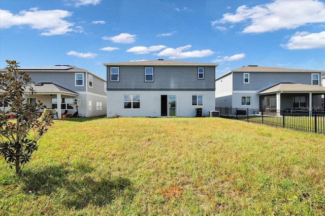 back of house with a lawn and central AC unit